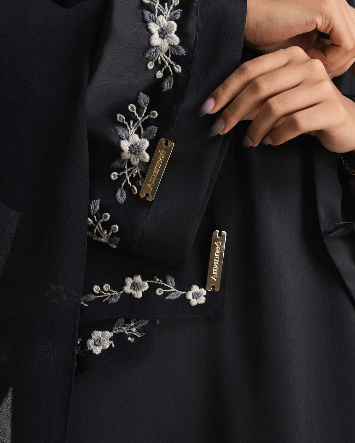 Ivory and silver-grey flowers embroidered on the black Jasmine abaya