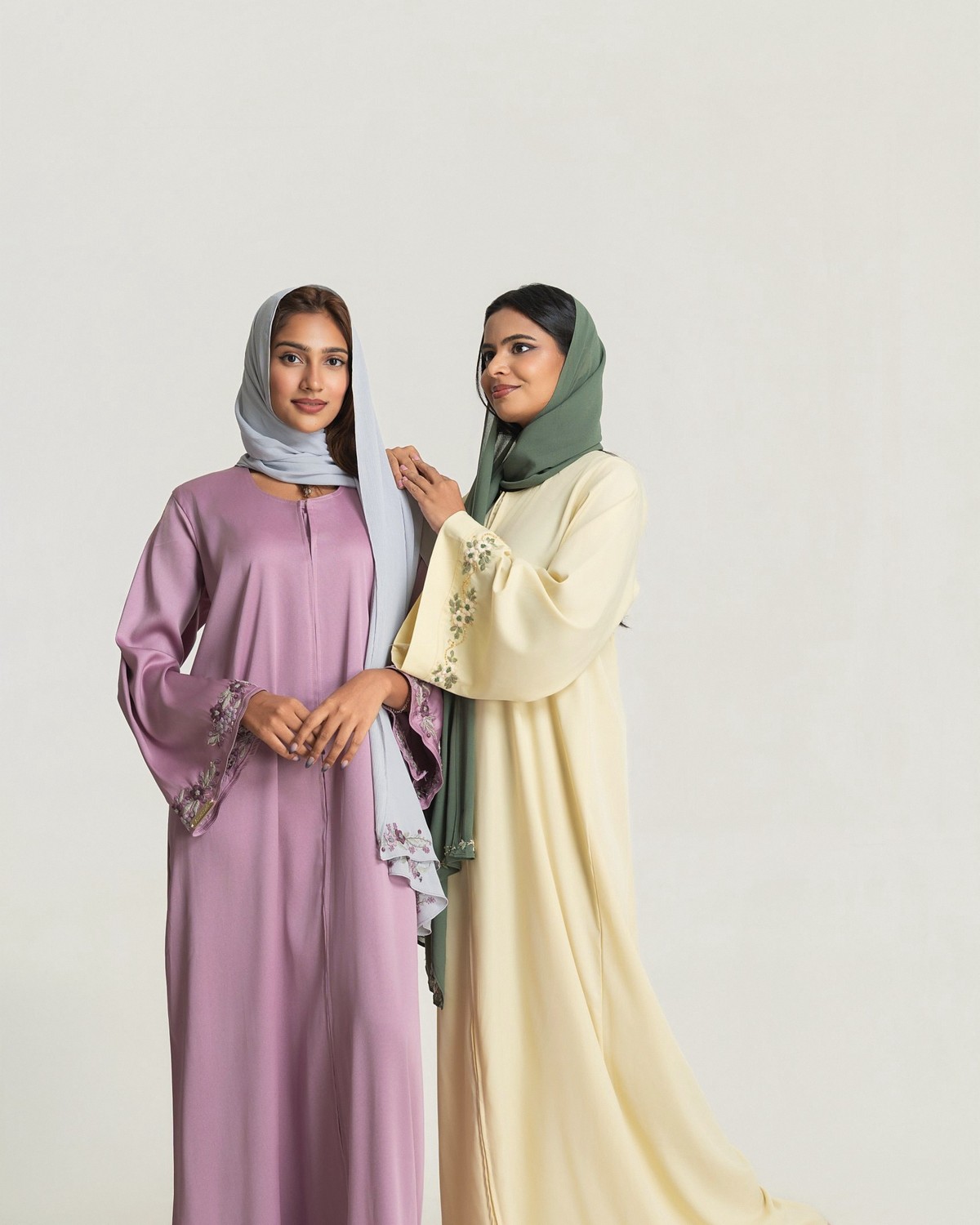 Two women in the Iris and Vanilla abaya sets, violet and buttercream